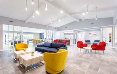 a living room with yellow chairs and couches and tables